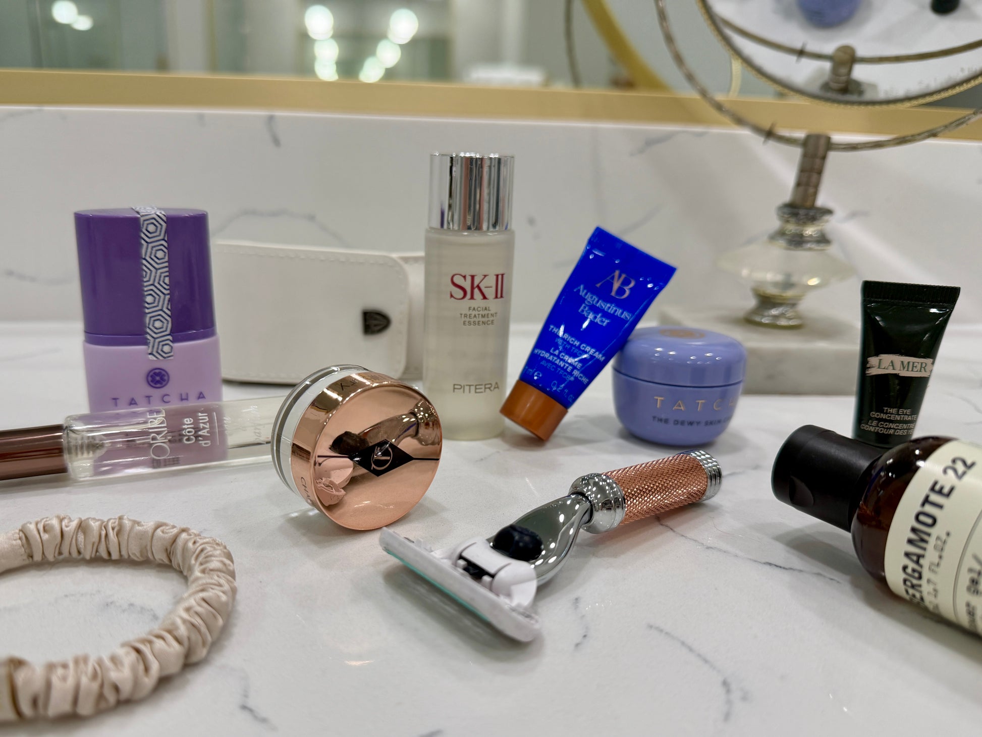 Luxury skincare, grooming, and beauty essentials arranged on a marble vanity for elevated travel organization