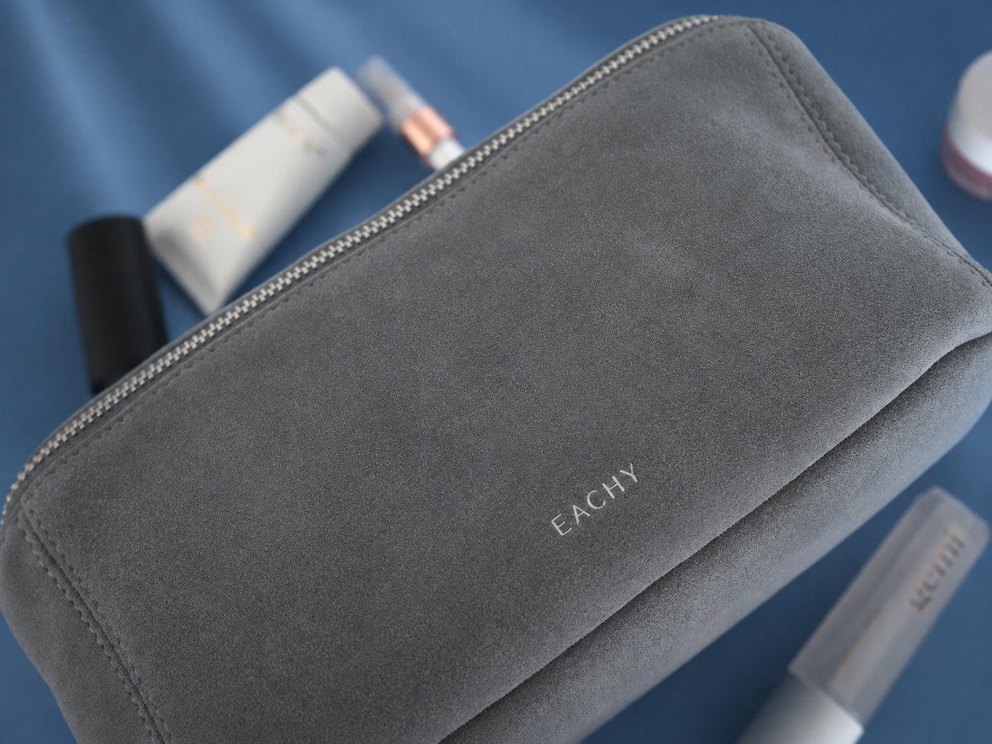 Luxury travel essentials organized inside the TESS Diamond cosmetic bag with skincare, beauty, and recovery items arranged for travel