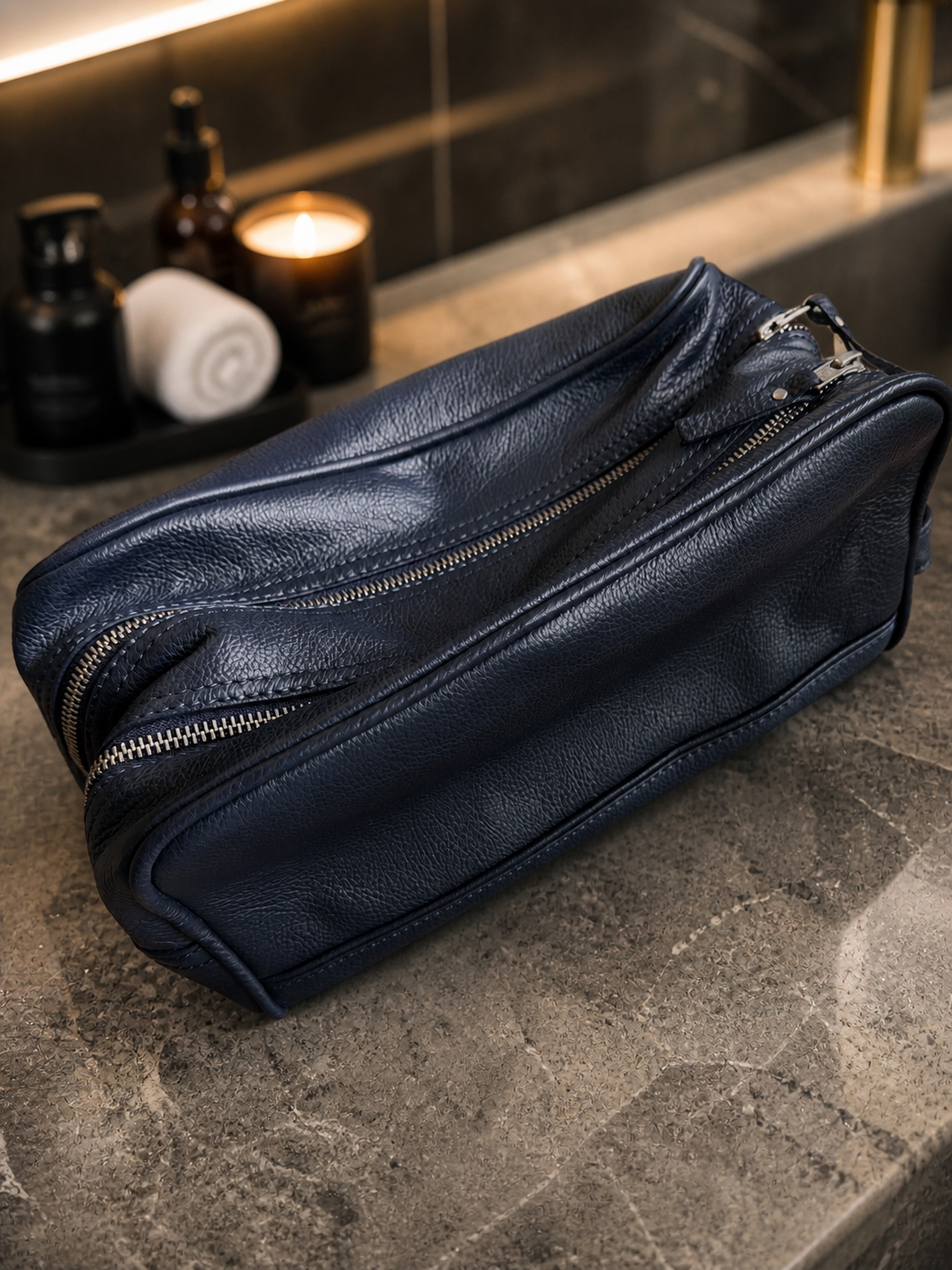 Luxury men’s travel bag styled on dark marble in a modern hotel-inspired setting