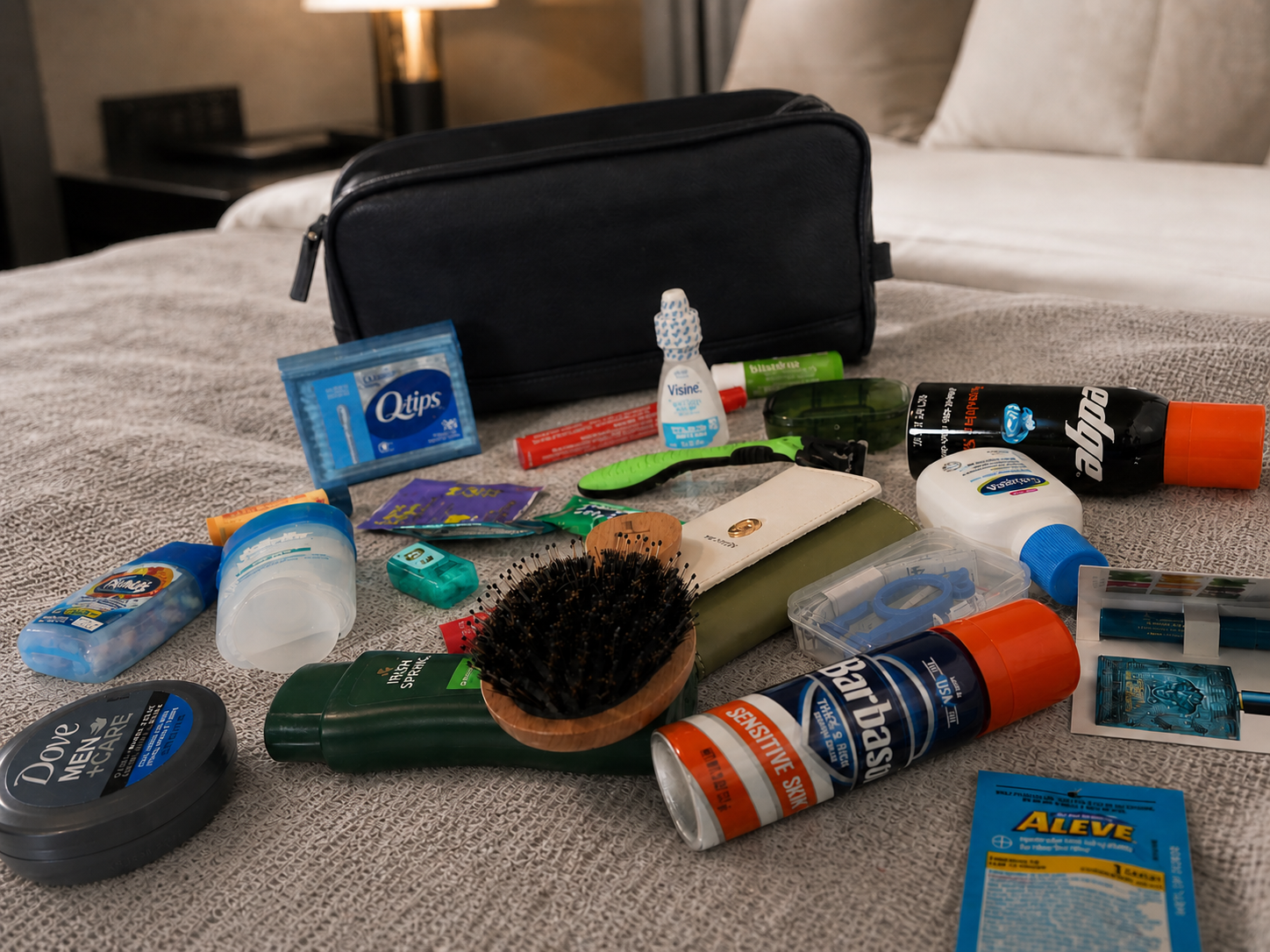 Curated men’s travel essentials arranged beside a black leather travel bag for organized travel